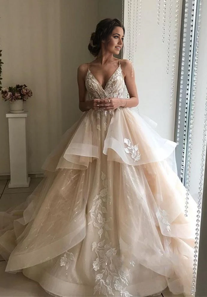 Vestidos de novia con tirantes finos, escote en V, sin mangas y capas.